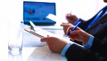 Businesspeople sitting on the desk on office .